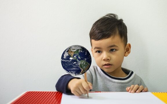 little boy looking at the world exploring the world learning. Elements of this image furnished by NASA