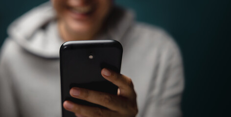 Blurred of a Happy Smilling Person Using Mobile Phone. Lifestyle of Modern People. Front View. Selective Focus on Smartphone