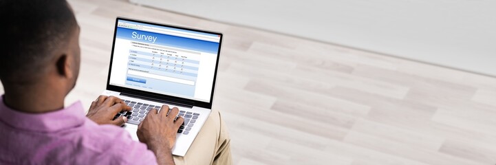 Man Giving Online Survey On Laptop