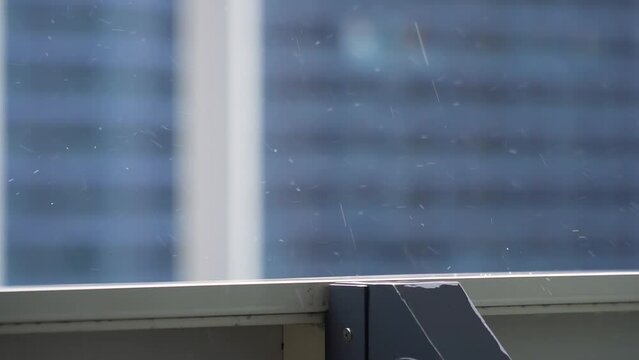 Raindrops close-up. Spring rain in sunny weather. The drop falls from above slow mo. Splashes of water on a blue background. Autumn weather. The wind blows away the precipitation.