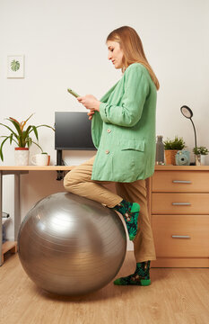 Woman Working From Home Uses Fitness Ball As A Chair