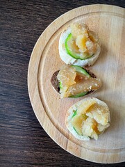 large vertical video. top view of a wooden board with small sandwiches. Herring caviar with cucumber slice on a piece of light and dark baguette. Source of omega-3. healthy snack. eco.