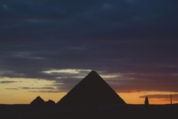 Sunset View to the One of the Wonders of the Ancient World - Great Pyramids of Giza with Colorful Sky and Evening Lights of the Sun, Egypt