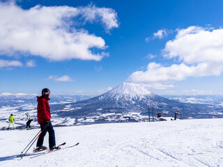 Skier with a snowy volcano (Niseko, Hokkaido, Japan)