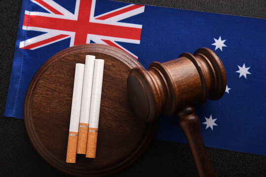 Cigarettes, wooden Judge gavel and flag of Australia. Top view. Justice and Tobacco law. Tobacco control act. Government duty. Illegal import.
