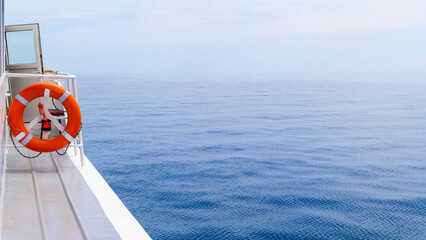 Railing on Cruise Ship with red Lifebelt and calm Sea in the Sun