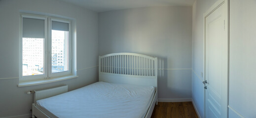 White bed in an empty bright room
