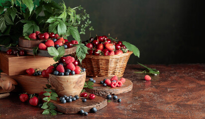 Assorted fresh berries with leaves.
