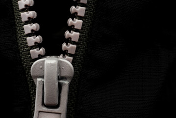 Lock with a gray zipper on black clothes close-up. Jacket clasp © Gudman