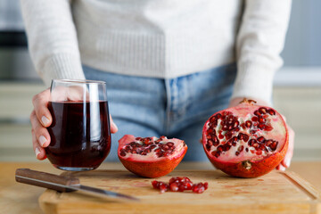 Young woman holding a glass of pomegranate juice.