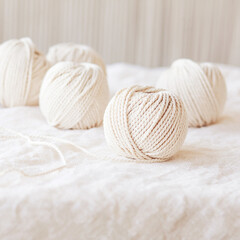 Handmade macrame braiding and cotton threads on white background. Light  image good for macrame and handicrafts banners and advertisement. Copy space