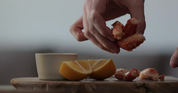 Slow motion man serving crab with dip sauce and sliced sweed lemon