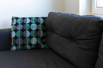 Dark blue sofa with blue and turquoise cushion in a white room