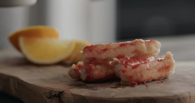 Slow motion man serving crab with dip sauce and sliced sweed lemon