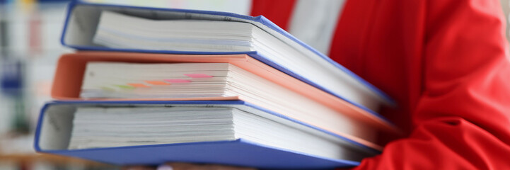 Woman holding a stack of folders with documents