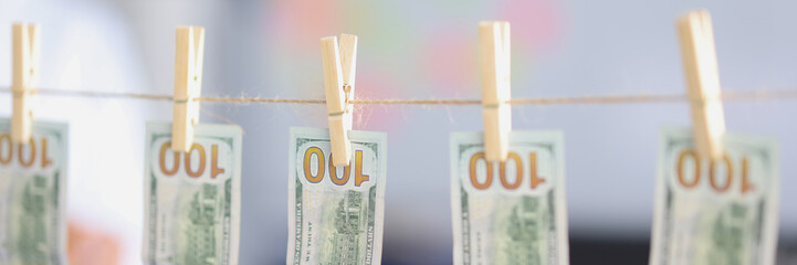 Hundred dollar bills hanging on clothespins close-up