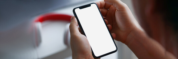 A man holds a smartphone, close-up of a hand with a phone.