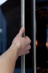 The hand opens the oven door. Kitchen equipment.