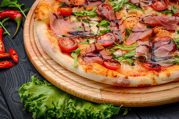 Delicious pizza with prosciutto and arugula.