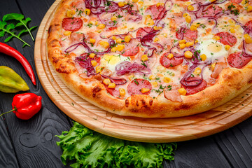 Pizza with quail eggs, ham, sausage and vegetables