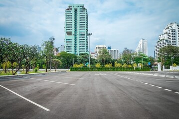 Empty space large outdoor asphalt car parking lot in city with city building background. Transport...