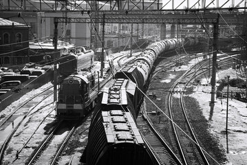 Black and white street photo with a large railway junction and a passing freight train. A train...