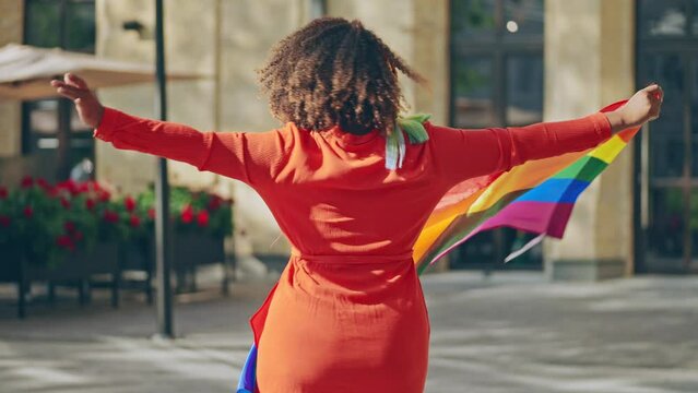 Happy black woman dancing with rainbow flag, lgbt movement, pride parade