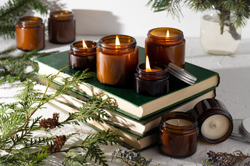 A set of different aroma candles in brown glass jars. Scented handmade candle. Soy candles are burning in a jar. Aromatherapy and relax in spa and home. Still life. Fire in brown jar
