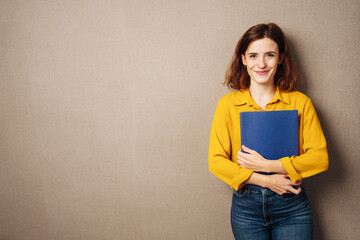 Naklejka premium young business woman with resume stands in front of brown background