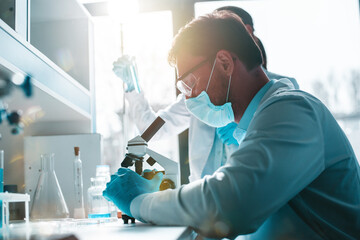 Doctor in the laboratory analyzes samples of codiv-9 under a microscope