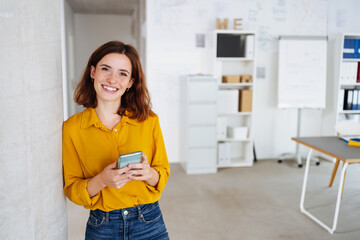 young modern business woman with cell phone laughs at camera