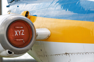 Technological plug of red color with an inscription XYZ on the engine of an old Ukrainian transport aircraft painted in national colors blue and yellow