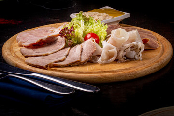 Thin slices of different meat: beef, pork, bacon, lie on a wooden board