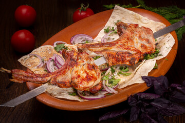 A lamb loin kebab on a skewer lies on a plate in a restaurant