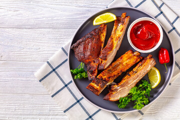 juicy roast pork ribs on plate, top view