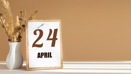 April 24. 24th day of month, calendar date.White vase with dead wood next to cork board with numbers. White-beige background with striped shadow. Concept of day of year, time planner, spring month