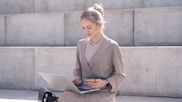 Young woman using laptop on street