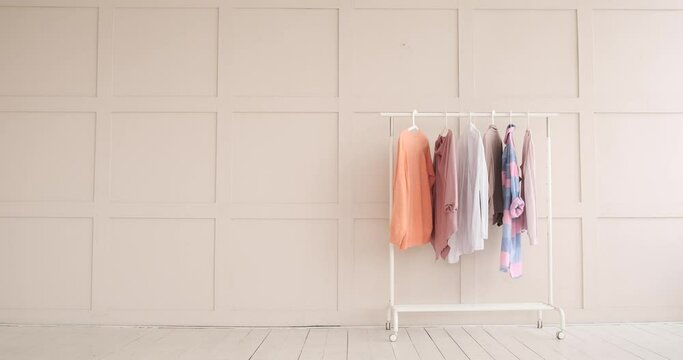 Stylish female clothes hanging on rack at boutique
