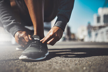 The best project youll ever work on is you. Shot of a sporty man tying his laces before a run.