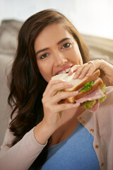 So much of yumminess. Shot of a young woman taking a bite out of a sandwich.