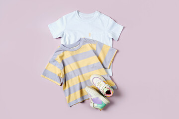 T-shirt  and sneakers. Baby clothes and accessories for spring, autumn or summer on pink...