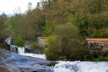 Cascades of the Barosa river next to old water mills in the forest