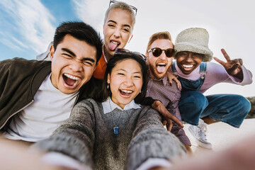 Multiracial best friends taking selfie picture outside - Mixed race teenagers having fun enjoying...