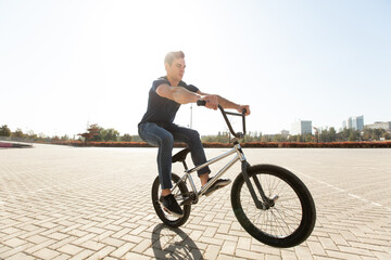 Street portrait of a bmx rider in a jump on the street in the background of the city landscape and...