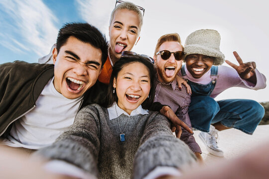 Multiracial best friends taking selfie picture outside - Mixed race teenagers having fun enjoying summertime day out together - Group of millenial people laughing at camera - Friendship concept
