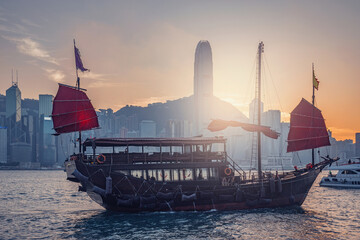 Retro small ship in Hong Kong harbour at sunset time.
