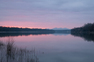 Fototapeta na wymiar Calm dusk over Sava river with fading light with mountain in haze - beautiful natural landscape