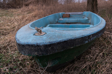 Bow of an old boat with an ring and a rope ashore in selective focus