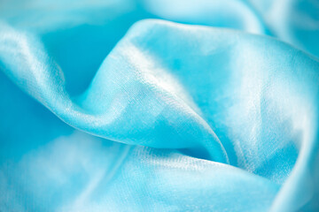 Satin fabric close up background and texture with place for text. Light blue chiffon or silk material. blurred background. blurred background, out of focus