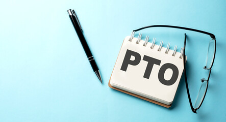 PTO text written on a notepad on the blue background